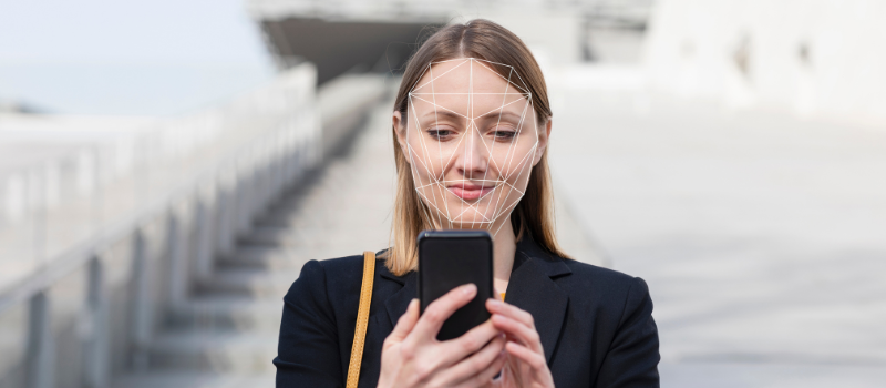 Femme qui s'authentifie sur son smartphone avec la reconnaissance faciale.